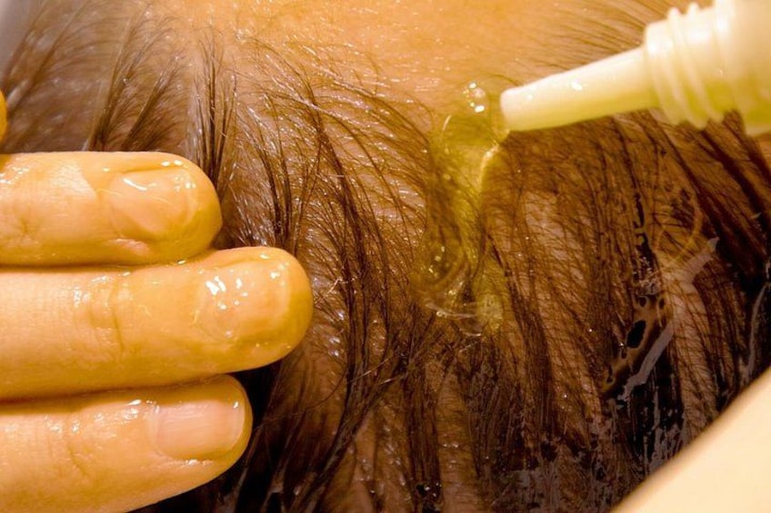 Primer plano de cabello siendo tratado con un líquido, posiblemente un tratamiento capilar o tinte. 2