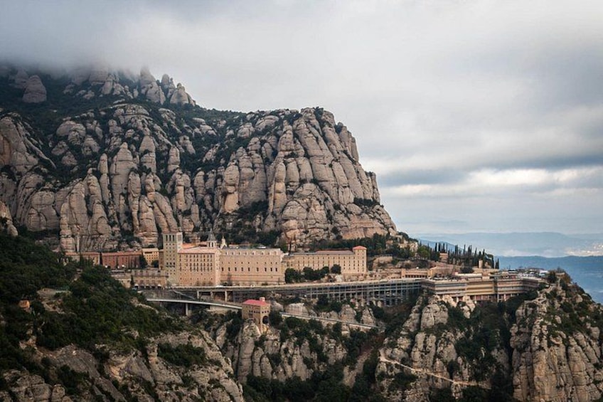A large building complex on a rocky hill with a bridge leading to it. 1