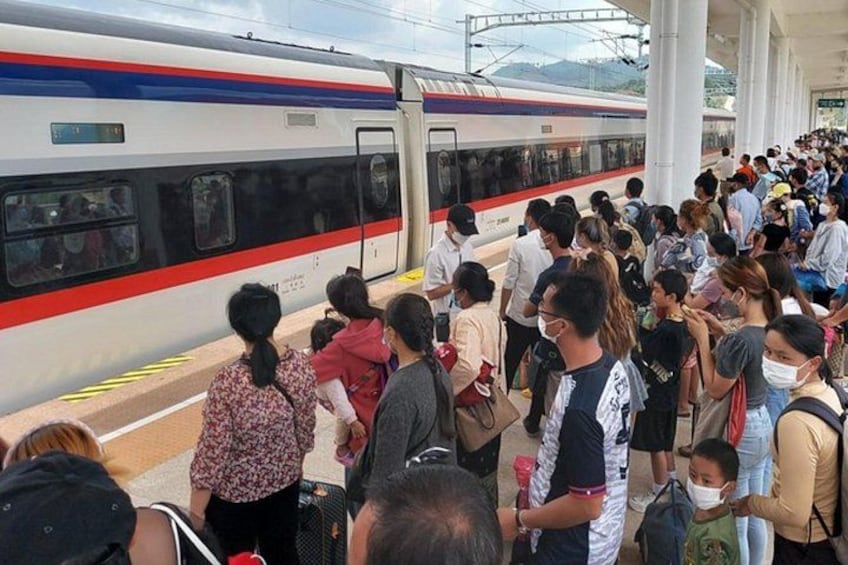 A crowded train station with passengers waiting for a train. 3