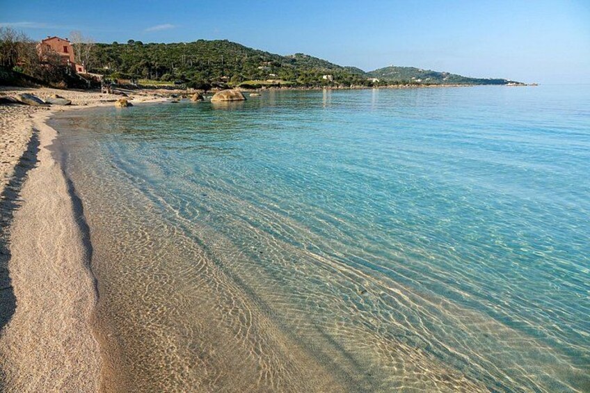 A clear beach with a sandy shore and calm water. 2
