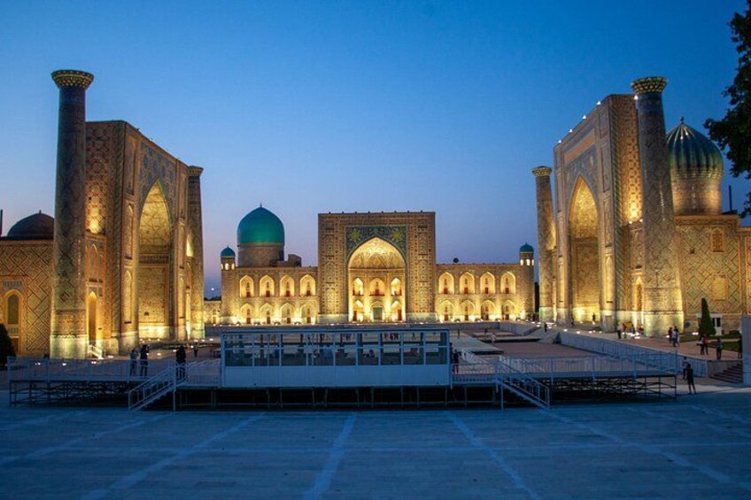 A large, illuminated mosque with domes and minarets, surrounded by a spacious courtyard. 5