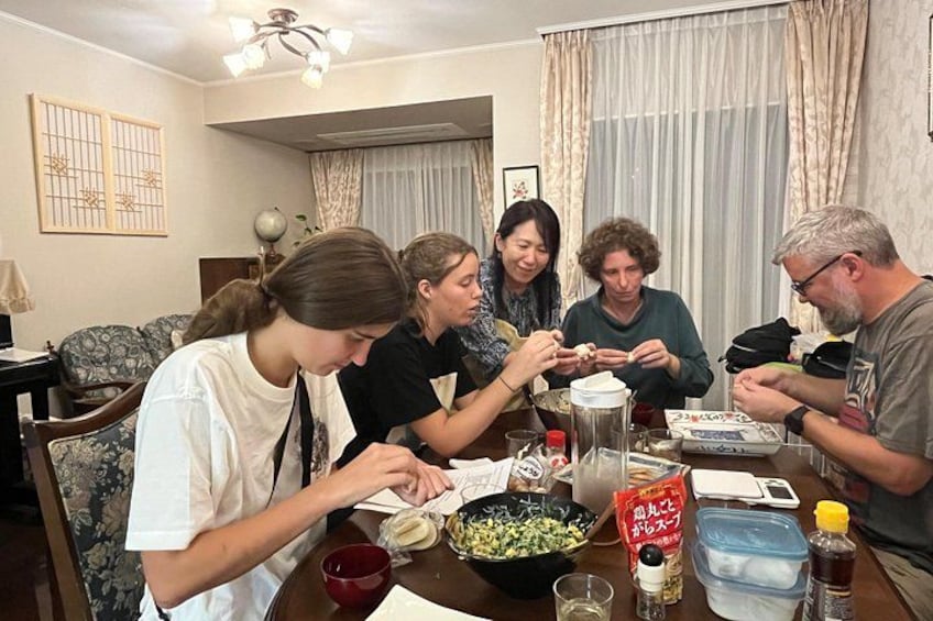 Un grupo de personas sentadas alrededor de una mesa, comiendo y bebiendo. 2