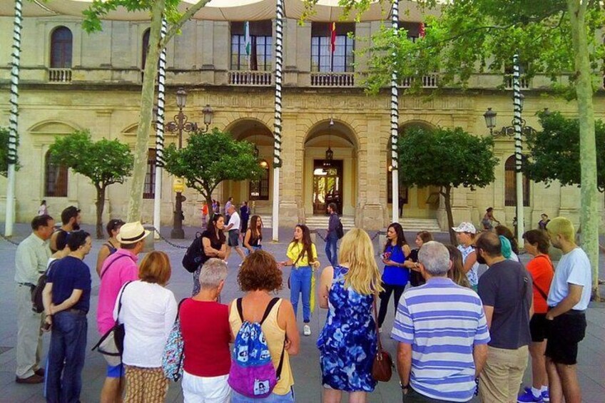 Un grupo de personas frente a un edificio histórico con columnas y arcos. 1