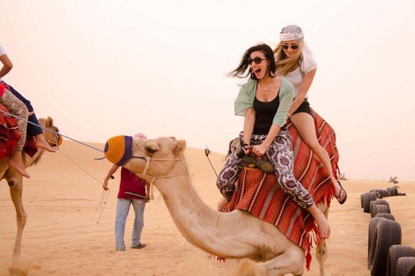 A camel with riders in a desert. 2
