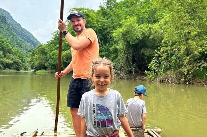 A river with people on a boat, surrounded by lush greenery and hills. 3