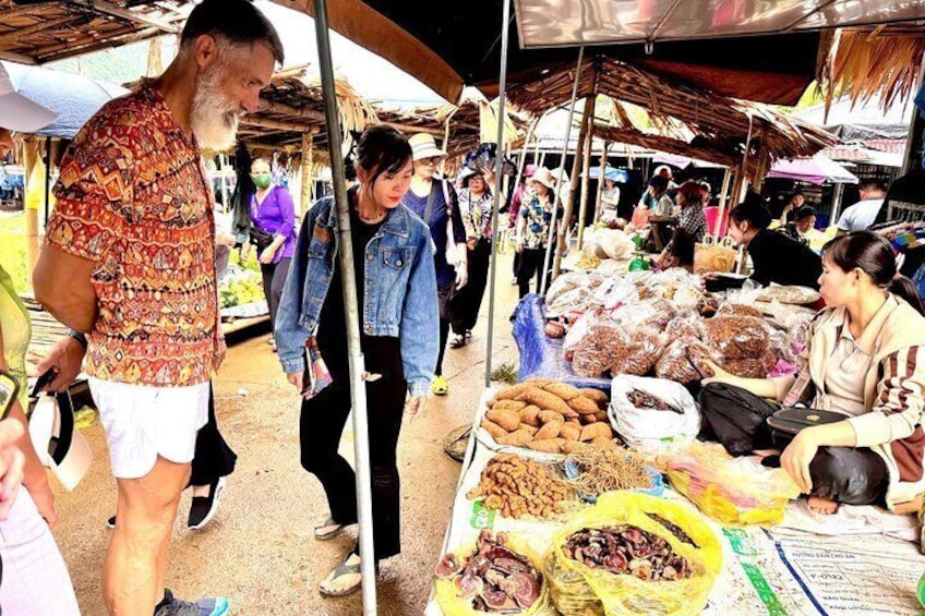 A bustling outdoor market with people shopping and vendors selling goods. 2