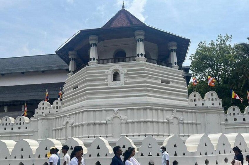 A white temple with a pointed roof and multiple flags. 1