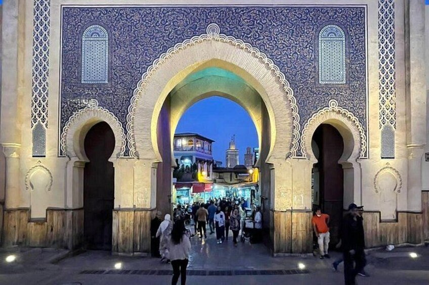 An ornate archway with intricate tile work, leading to a bustling street scene. 4