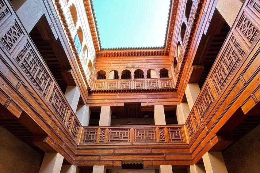 A courtyard with intricate wooden lattice work and arches. 5