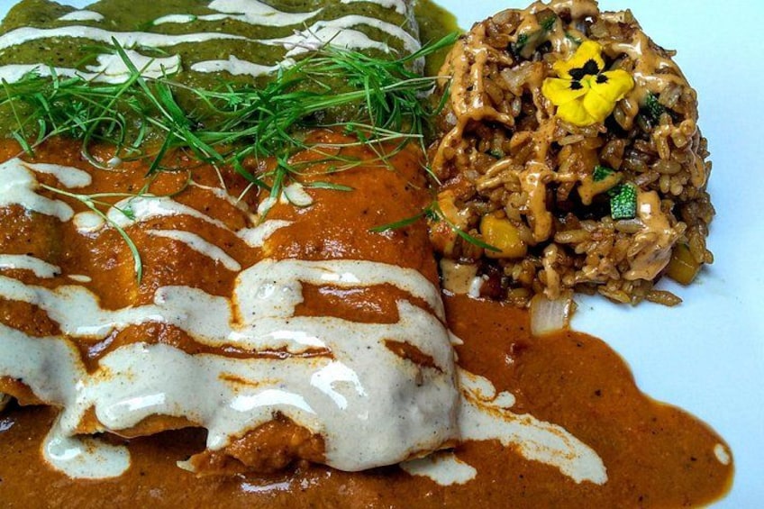 Un plato de enchiladas con salsa cremosa y arroz como guarnición. 4