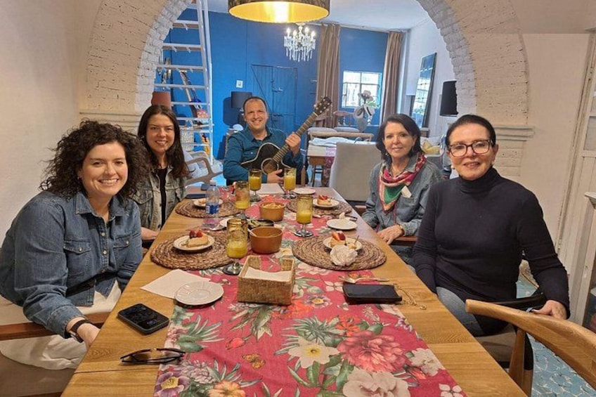 Un grupo de personas sentadas alrededor de una mesa con comida y bebidas. 2
