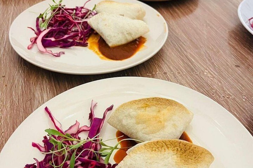 Un plato con dos dumplings y una guarnición de col morada. 3