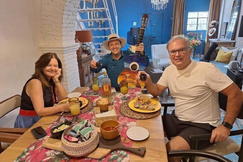 Un grupo de personas sentadas alrededor de una mesa con comida y bebidas. 4