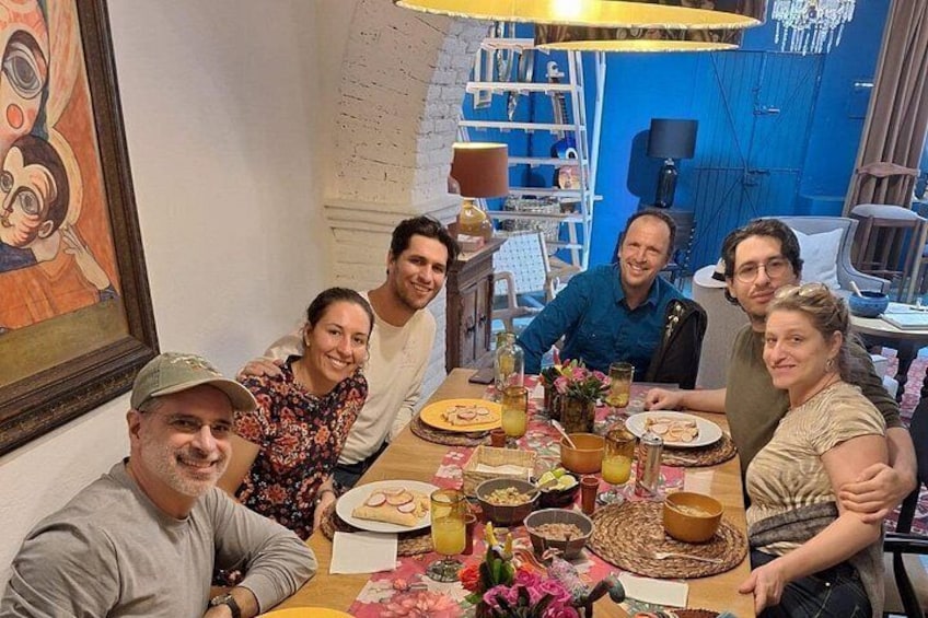 Un grupo de personas sentadas alrededor de una mesa con comida y bebidas. 5