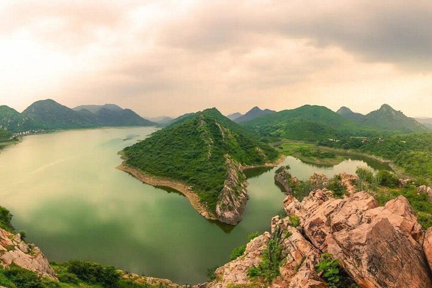 A river winding through a mountainous landscape with rocky outcrops and dense greenery. 2