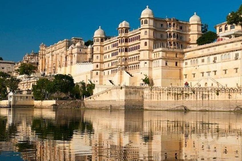 A historic building with domed structures and a reflection in the water. 3
