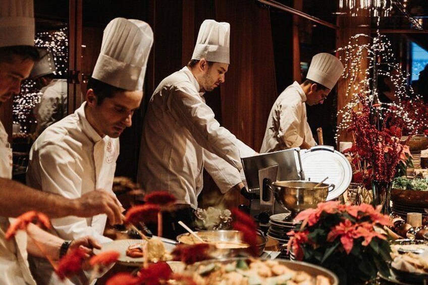 Chefs in white uniforms preparing food in a kitchen with a festive decoration. 2