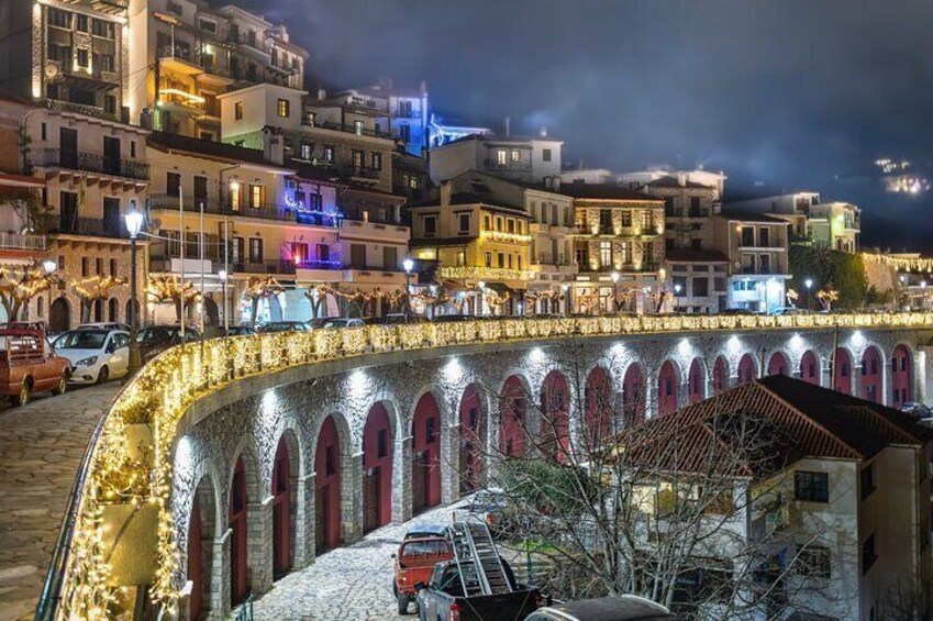 A nighttime view of a historic town with illuminated buildings and a stone bridge. 4