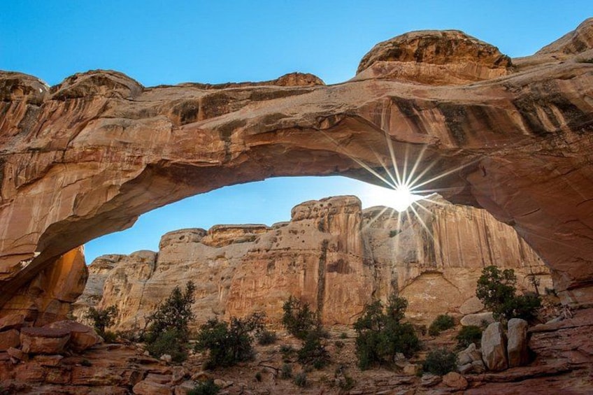 A natural rock arch formation with the sun shining through it. 2