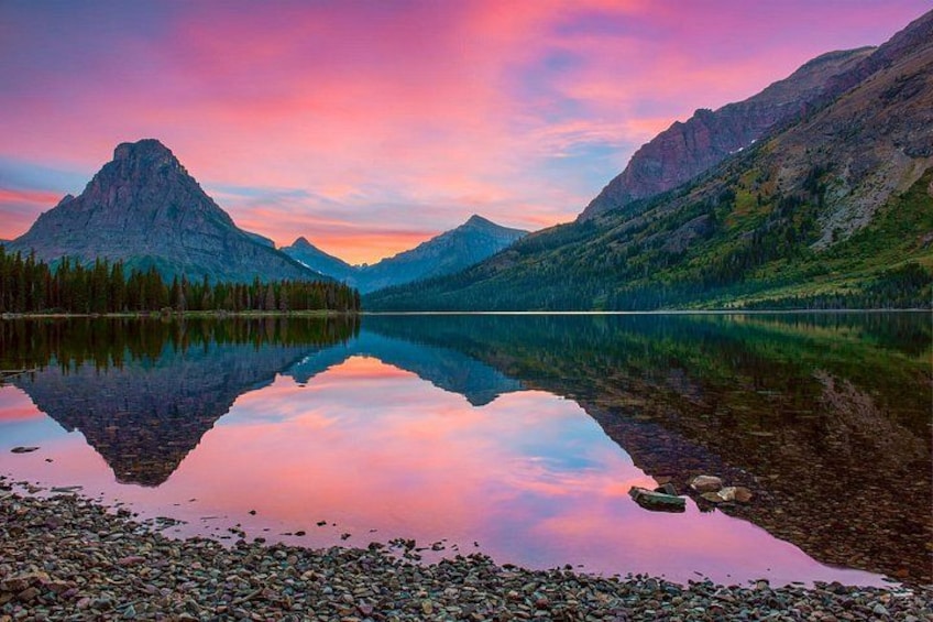 Un lago di montagna con riflessi, circondato da montagne boscose. 1