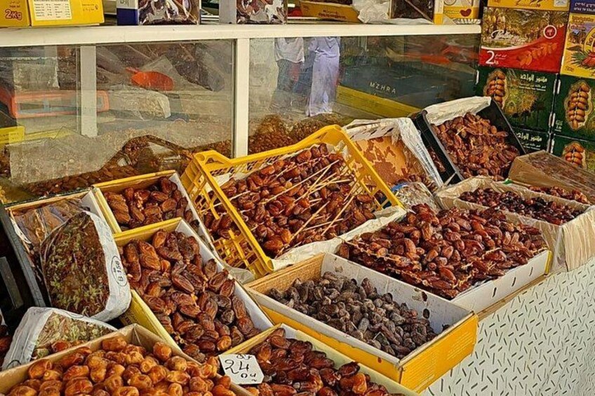 A variety of nuts and dried fruits displayed in boxes at a market stall. 2