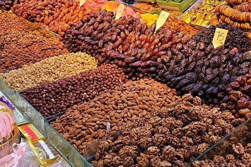 A variety of nuts and dried fruits displayed in a market. 4
