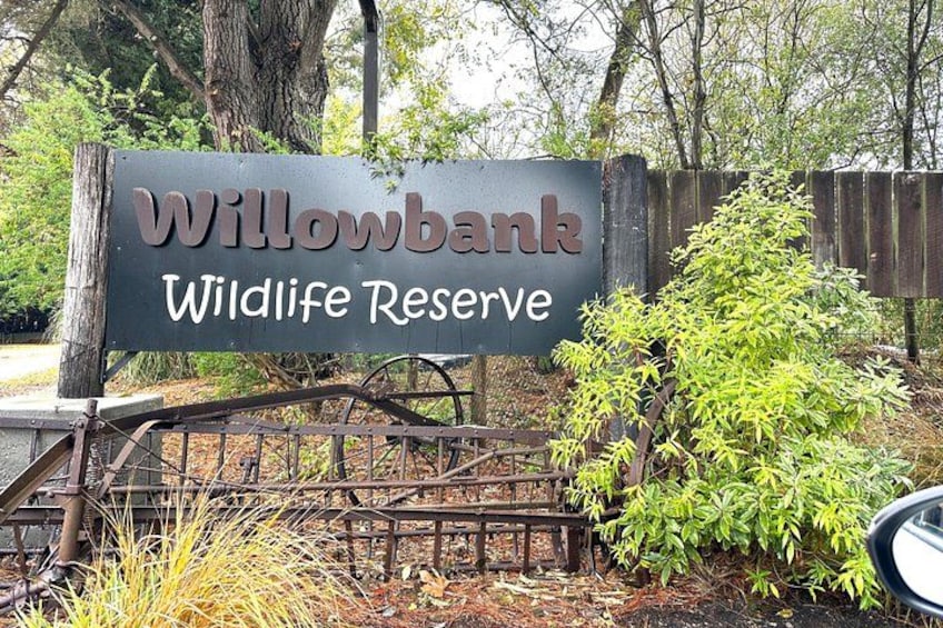 Un panneau indiquant la réserve naturelle de Willowbank, avec une clôture rustique et de la verdure. 2