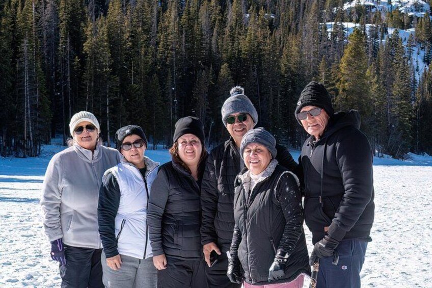 Un grupo de personas sobre suelo nevado, con árboles y montañas al fondo. 2