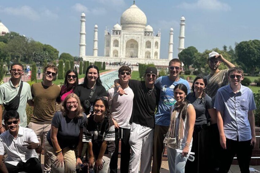 A group of people posing in front of the Taj Mahal. 1