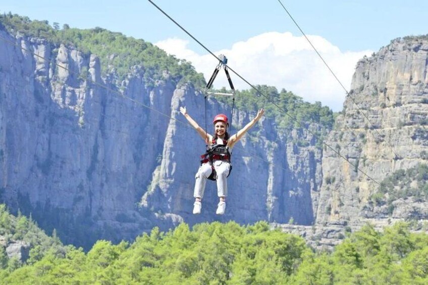 A person bungee jumping with arms outstretched, surrounded by a mountainous landscape. 2