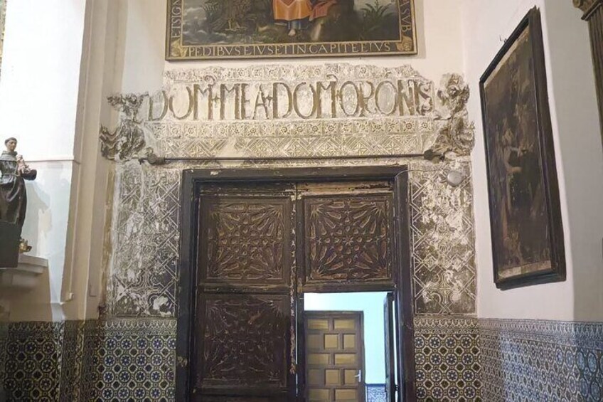 Una entrada imponente con adornos elaborados y una gran puerta de madera. 4