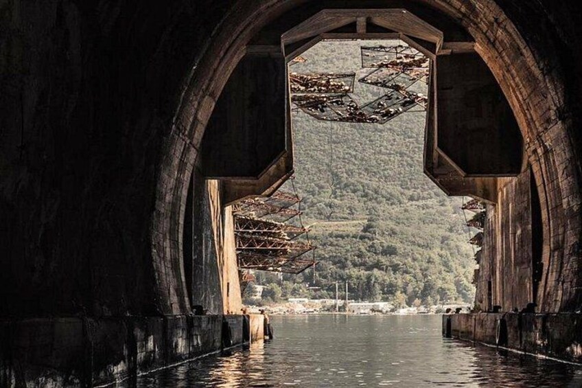 Una gran estructura arqueada que ofrece vista a una ladera boscosa a través de una abertura central. 2