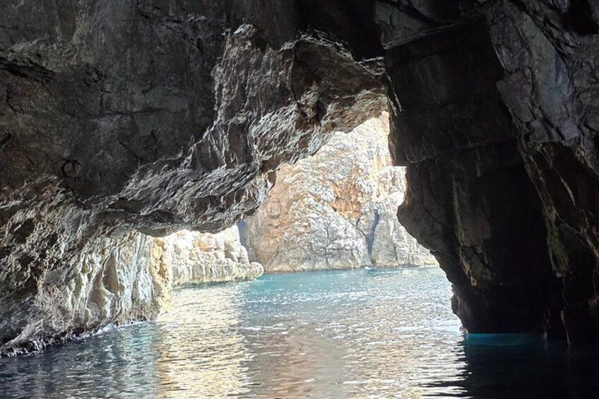 Formación rocosa natural con una abertura de cueva que da a una masa de agua. 2