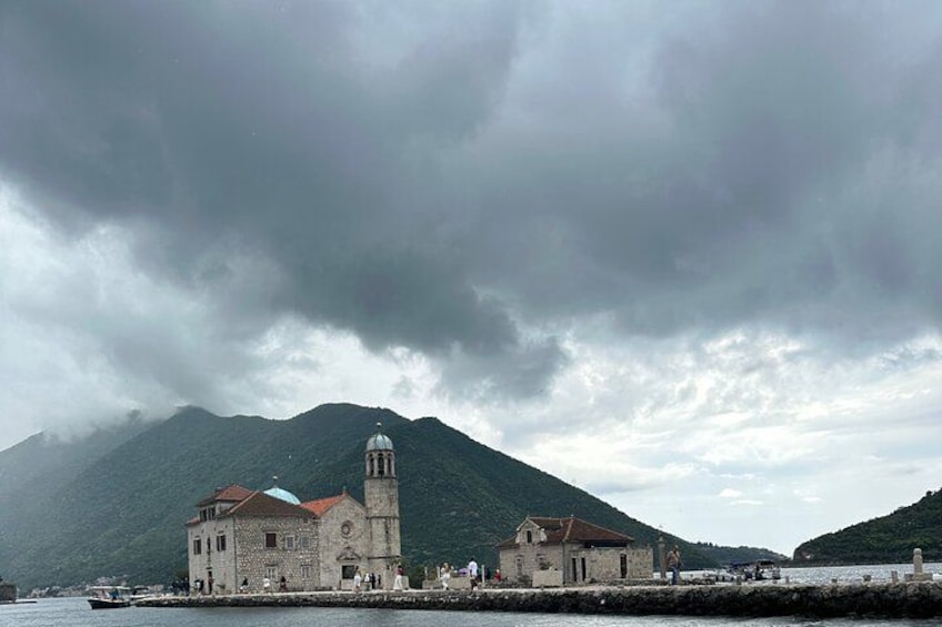 Une ville côtière avec une église imposante, une montagne en arrière-plan et une étendue d'eau au premier plan. 5