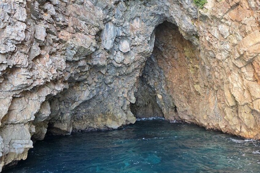Entrada a una cueva rocosa con agua azul cristalina en el fondo. 3