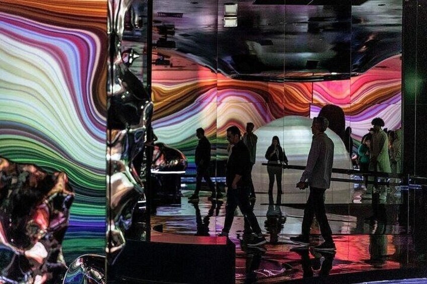 A modern building with a reflective glass facade and a colorful, abstract mural. 4