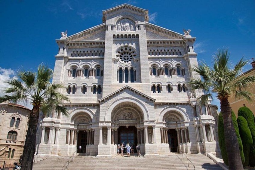 A grand, historic building with a large arched entrance, intricate architectural details, and a prominent clock tower. 3