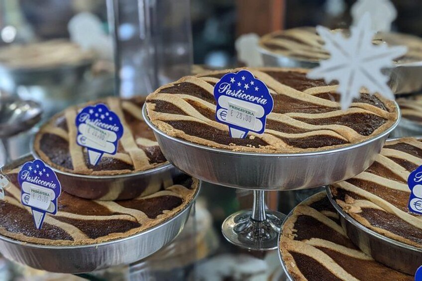 Exhibición de postres de pastelería en bandejas metálicas con etiquetas de precio. 2