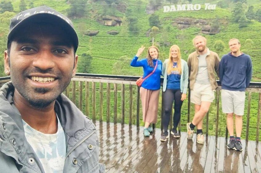 A group of people on a wooden deck with a lush green landscape in the background. 5