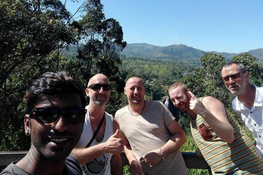 A group of people standing outdoors with a mountainous landscape in the background. 5