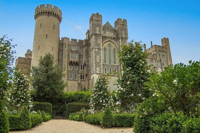 A castle with a tower, arched windows, and a gravel pathway. 3