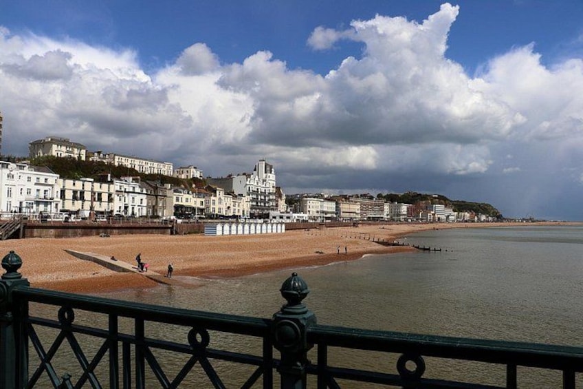 A coastal cityscape with a beach, a promenade, and buildings along the shore. 2