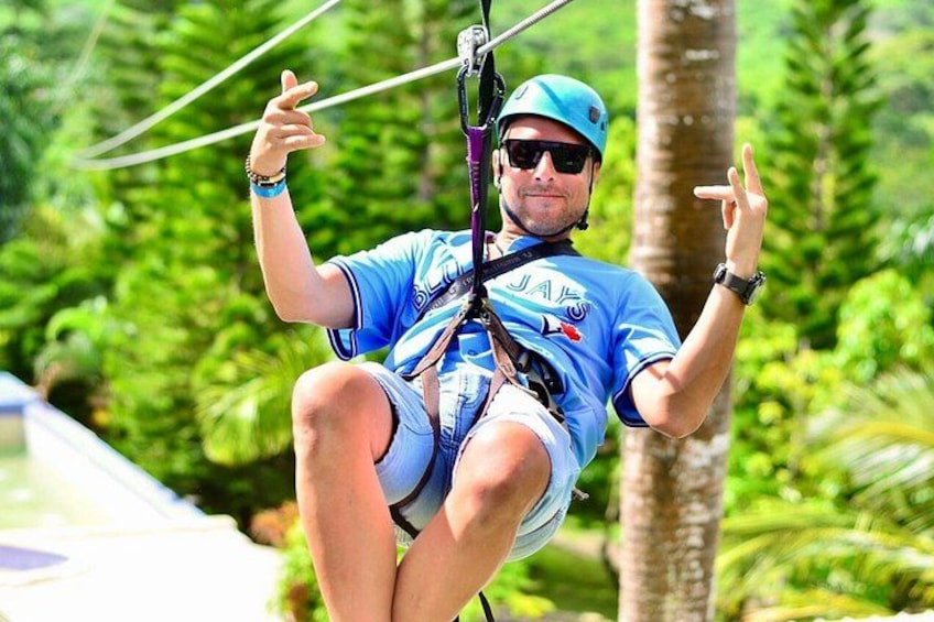 A person windsurfing, wearing a blue helmet and a blue shirt, with a parasail attached to their board. 1