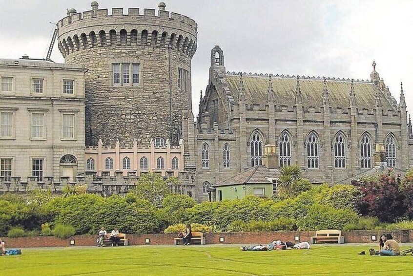 A historic castle with a round tower and a large building with arched windows. 5