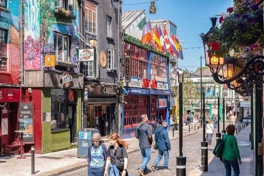 A colorful street with shops and people walking. 4