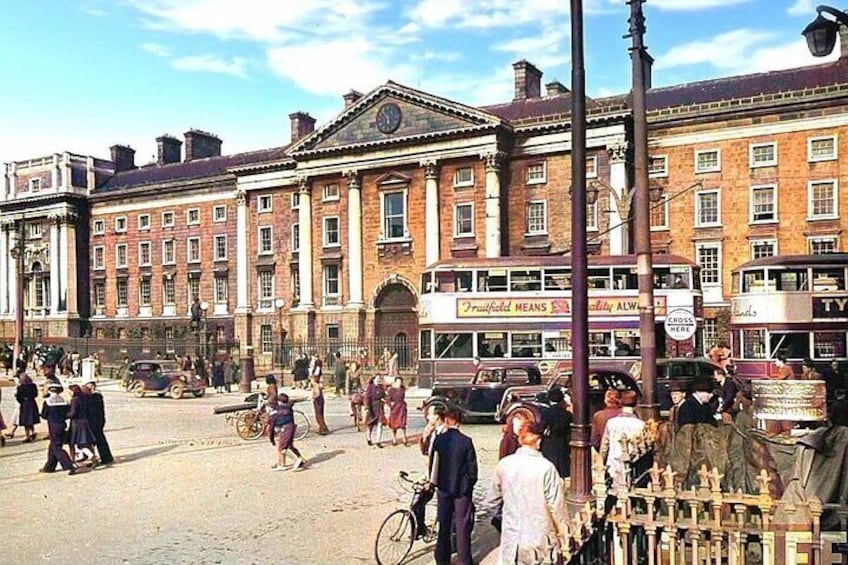 A busy street with vintage cars, a double-decker bus, and pedestrians. 1