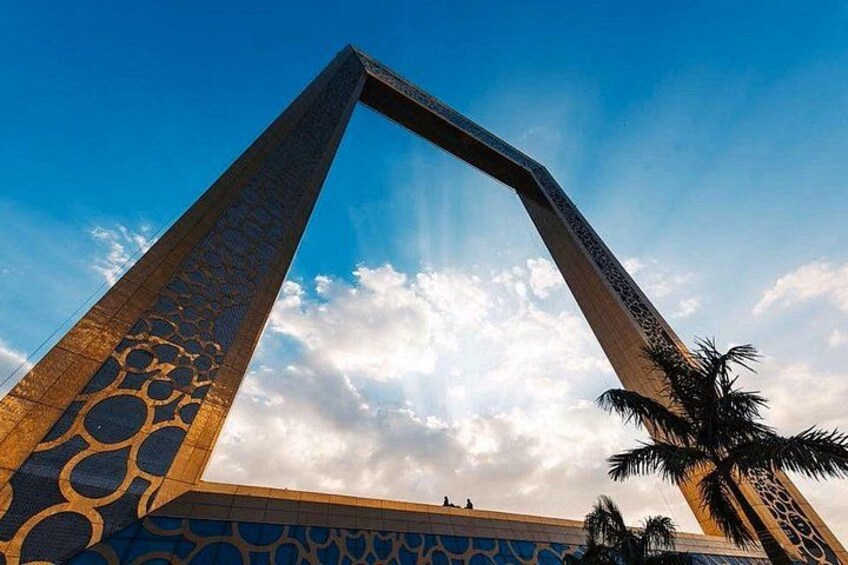 A tall, triangular monument with intricate patterns, set against a clear sky with clouds. 3