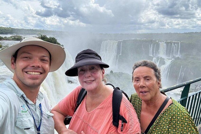 Three people standing in front of a waterfall. 4