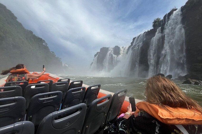 A boat tour with a waterfall in the background. 1