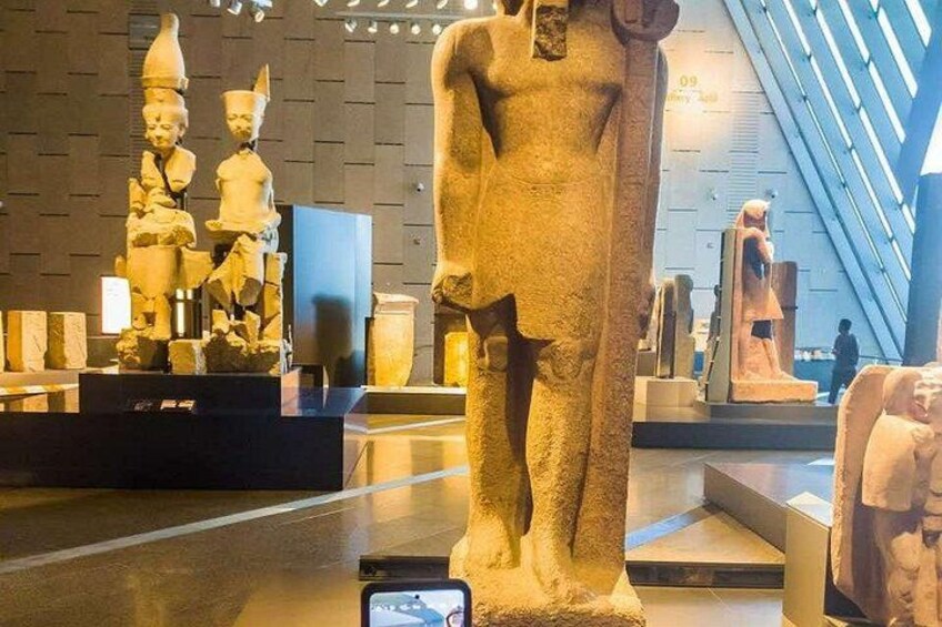 A museum interior with ancient Egyptian statues and artifacts on display. 3